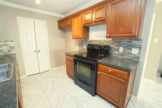a kitchen with stainless steel appliances granite countertop a stove a sink and a microwave