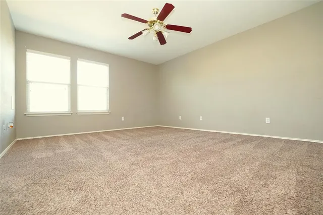 an empty room with a window and a fan