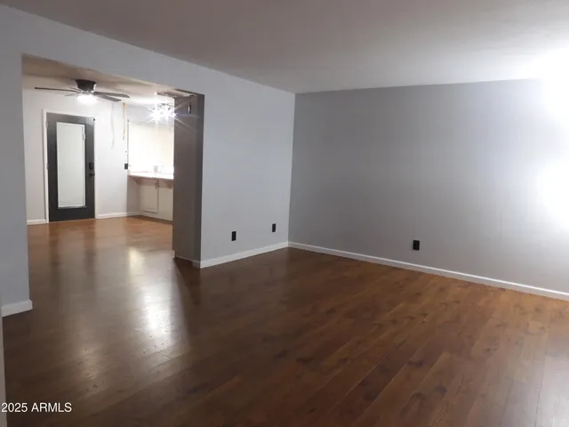an empty room with wooden floor and a window