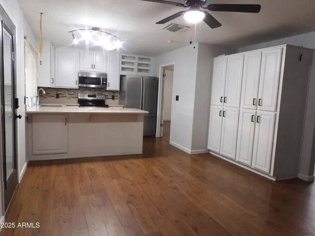 a view of kitchen with stainless steel appliances refrigerator oven and cabinets