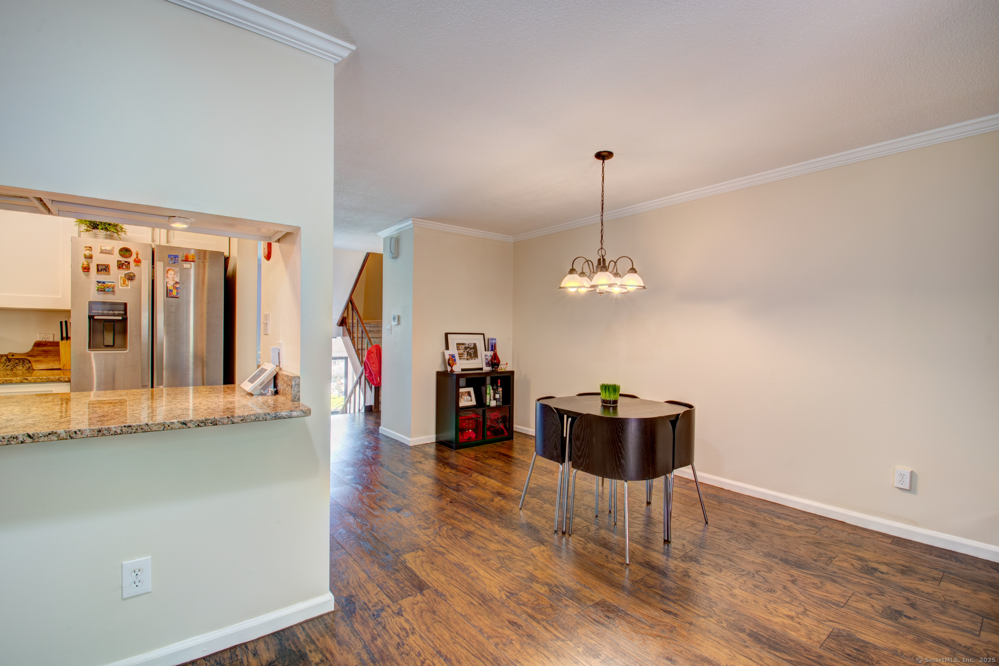 184 Gravel Street, Unit 26 Meriden, CT 06450 - Photo 4 of 27 a dining room with wooden floor a chandelier a wooden table and chairs