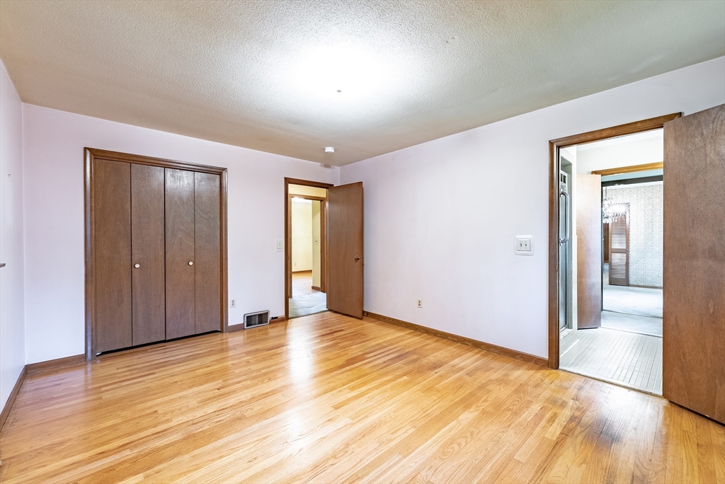 122 Benz Street Springfield, MA 01118 - Photo 17 of 28 a view of an empty room with wooden floor and a window