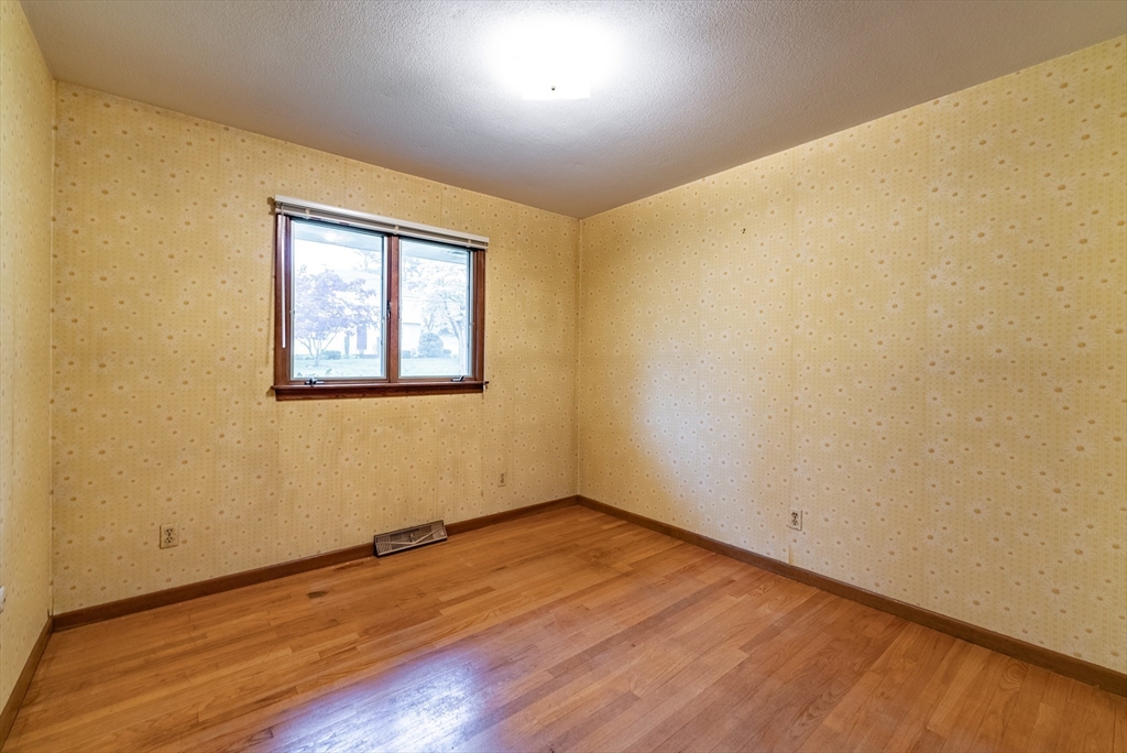 122 Benz Street Springfield, MA 01118 - Photo 23 of 28 an empty room with wooden floor and windows