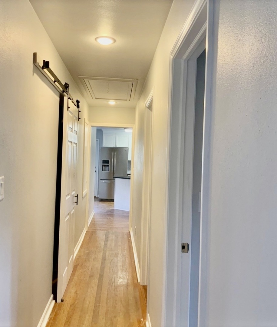 3929 Pinecrest Road Rockford, IL 61107 - Photo 14 of 33 a view of a hallway with wooden floor and a bathroom