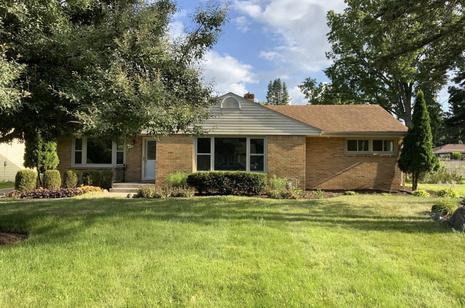 3929 Pinecrest Road Rockford, IL 61107 - Photo 3 of 33 a front view of a house with a garden and trees