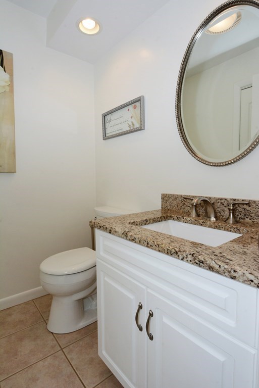 52 Powder Hill Way, Unit 52 Westborough, MA 01581 - Photo 13 of 38 a bathroom with a granite countertop toilet and a mirror