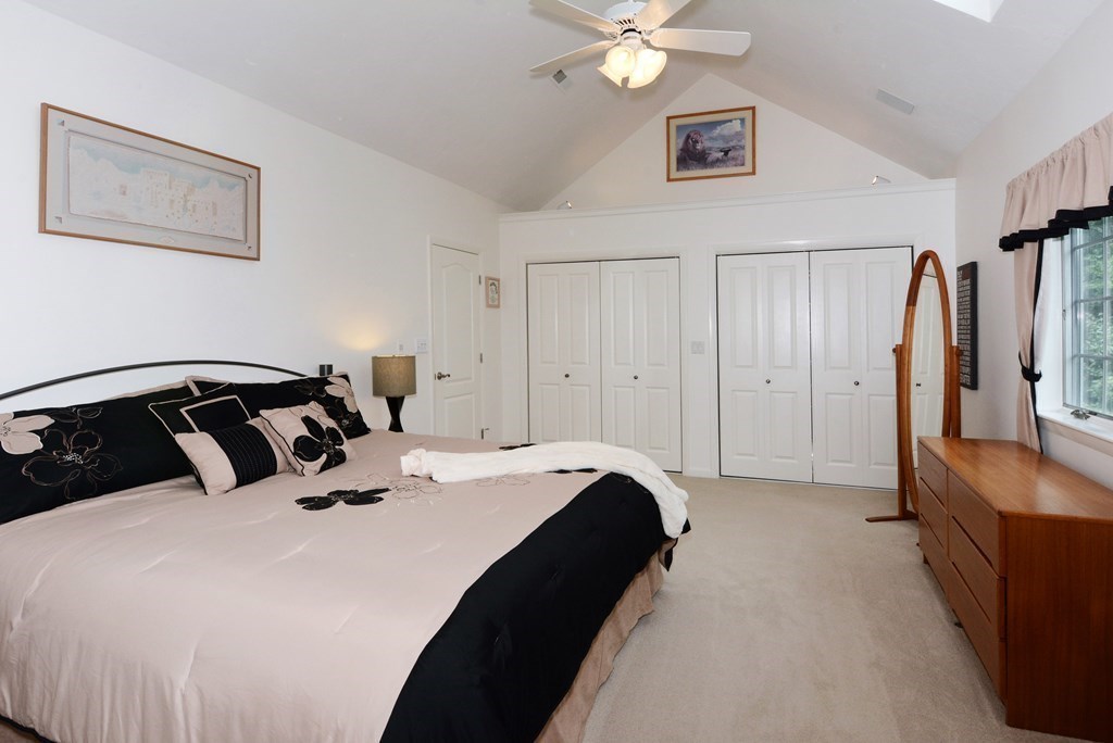 52 Powder Hill Way, Unit 52 Westborough, MA 01581 - Photo 17 of 38 a bedroom with a bed and a chandelier