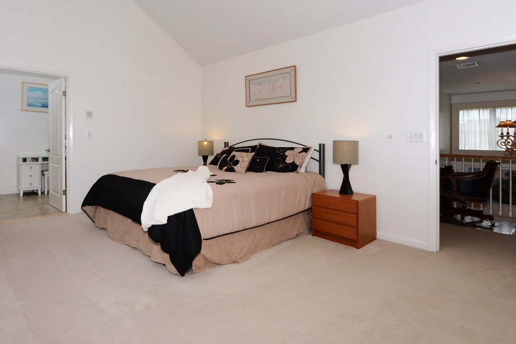 52 Powder Hill Way, Unit 52 Westborough, MA 01581 - Photo 18 of 38 a bedroom with a bed lamp and a computer on a dresser