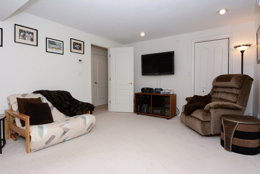 52 Powder Hill Way, Unit 52 Westborough, MA 01581 - Photo 26 of 38 a living room with furniture and a flat screen tv