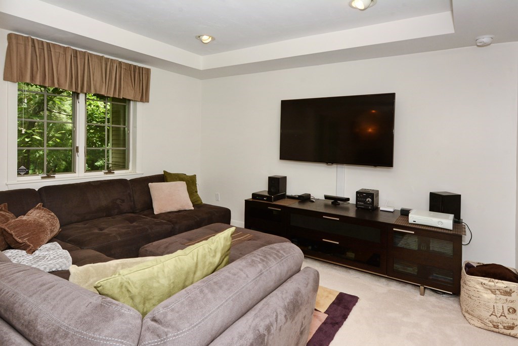52 Powder Hill Way, Unit 52 Westborough, MA 01581 - Photo 28 of 38 a living room with furniture and a flat screen tv