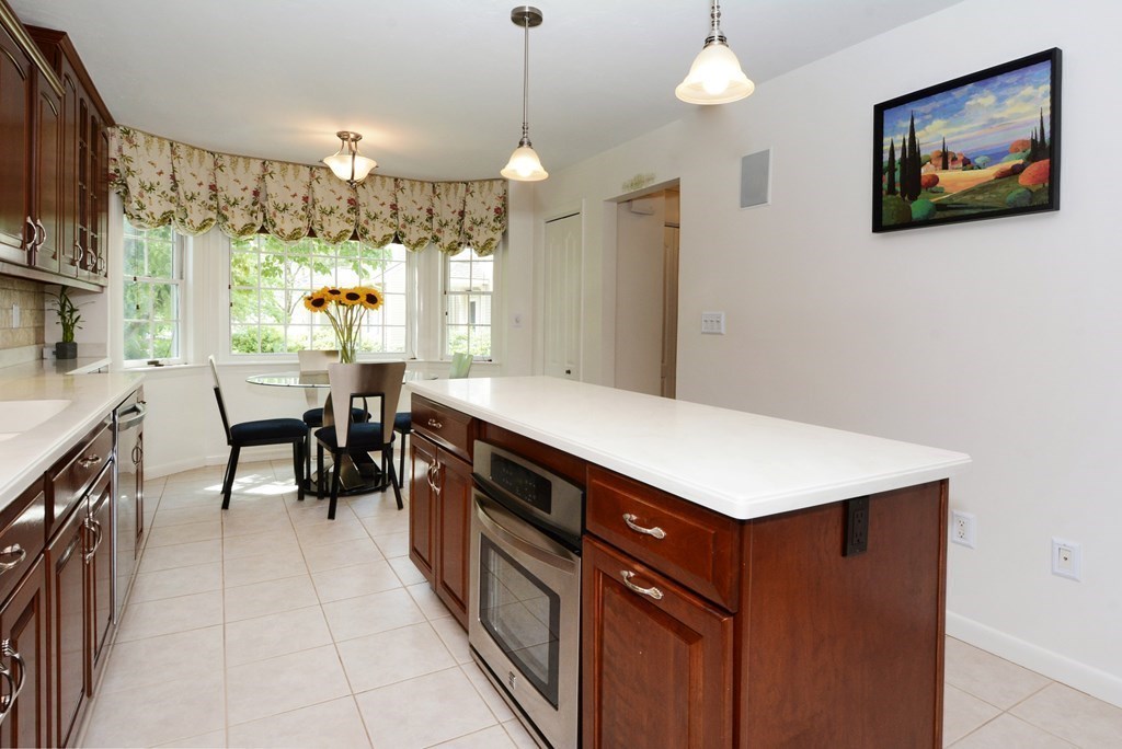 52 Powder Hill Way, Unit 52 Westborough, MA 01581 - Photo 3 of 38 a kitchen with a stove a refrigerator a sink dishwasher with a dining table and chairs