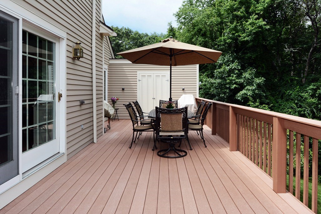 52 Powder Hill Way, Unit 52 Westborough, MA 01581 - Photo 32 of 38 a view of a roof deck with table and chairs under an umbrella with wooden floor