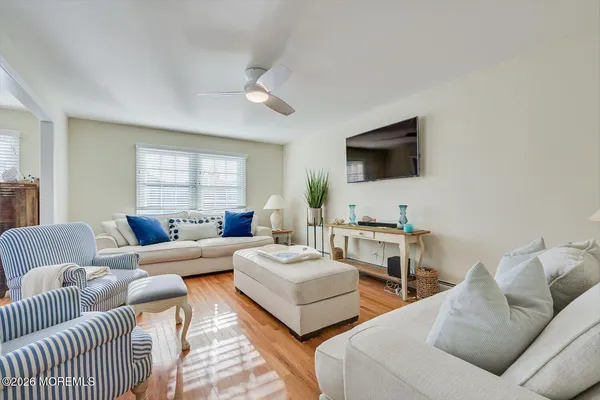 a kitchen with stainless steel appliances granite countertop a stove top oven a sink a dining table and chairs with wooden floor