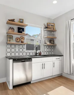 a kitchen with stainless steel appliances granite countertop a stove and a white cabinets