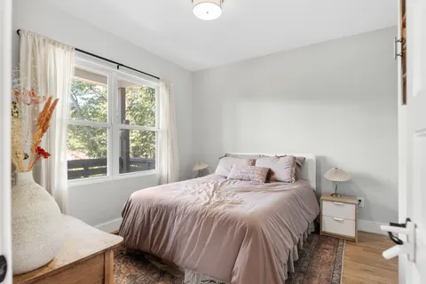 a bedroom with a bed and wooden floor