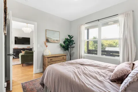 a bedroom with a bed and a large window