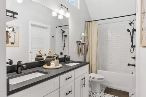 a bathroom with a sink a toilet and shower