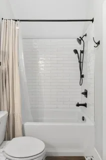 a bathroom with a toilet and a shower