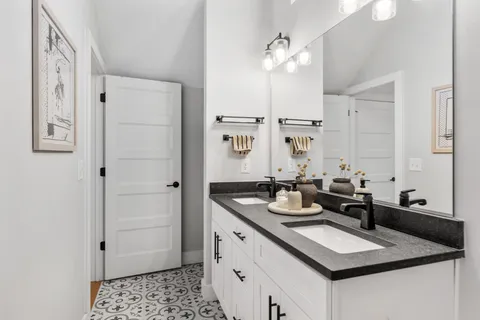 a bathroom with a sink double vanity granite and a mirror