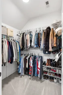 a view of walk in closet with clothes and shoes