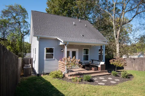 a view of house with backyard and outdoor seating