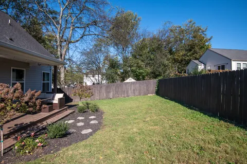 a view of a backyard with potted plants and large tree