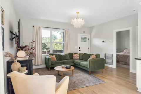 a living room with furniture chandelier and a window
