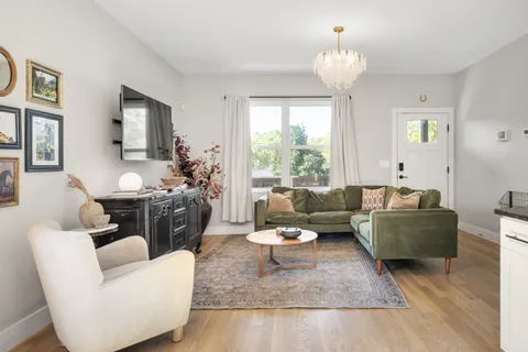 a living room with furniture and a chandelier