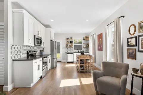 a living room with stainless steel appliances kitchen island granite countertop furniture and a kitchen view