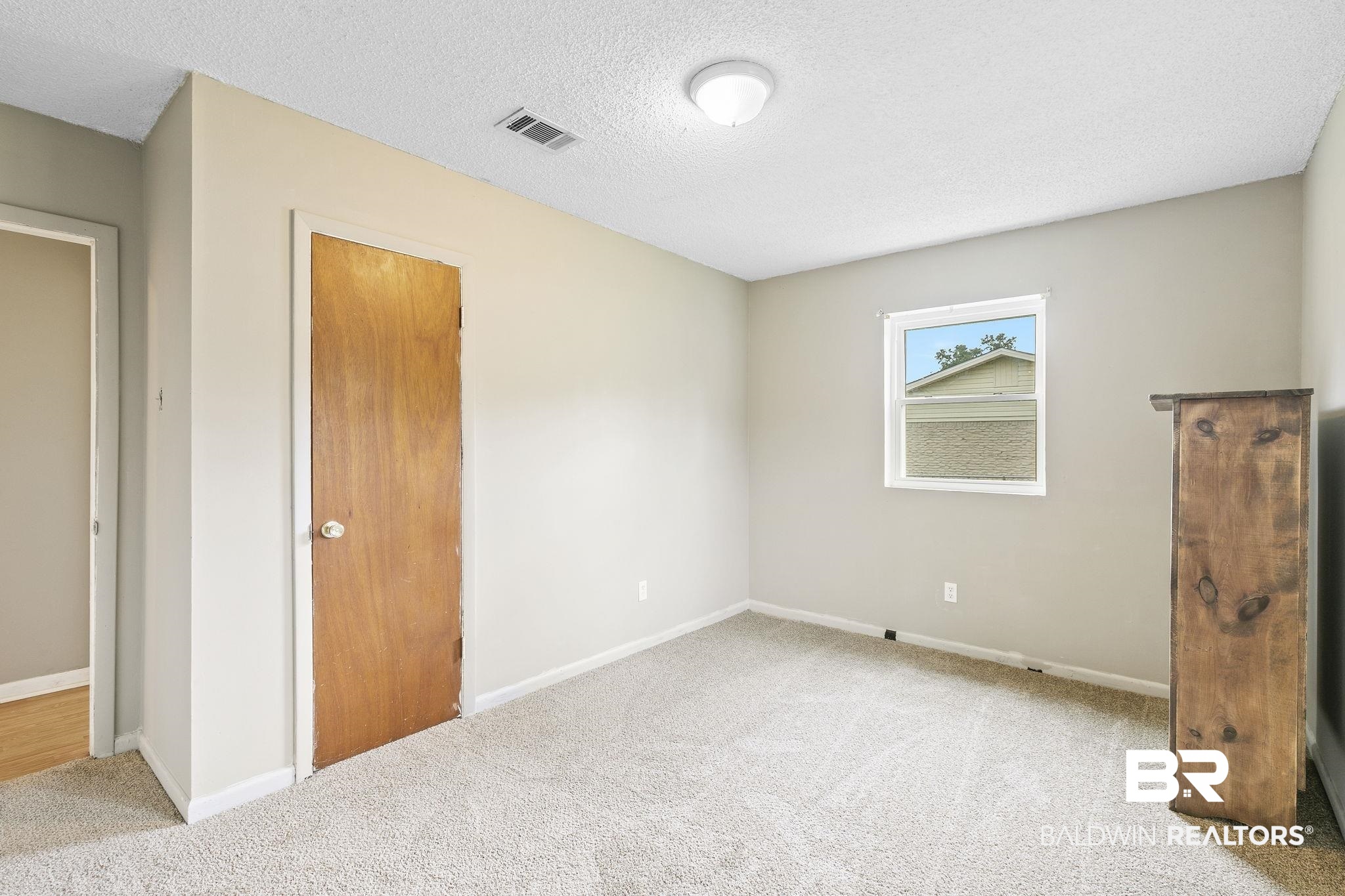 13108 6th Street Lillian, AL 36549 - Photo 27 of 39 Spare room featuring light carpet and a textured ceiling
