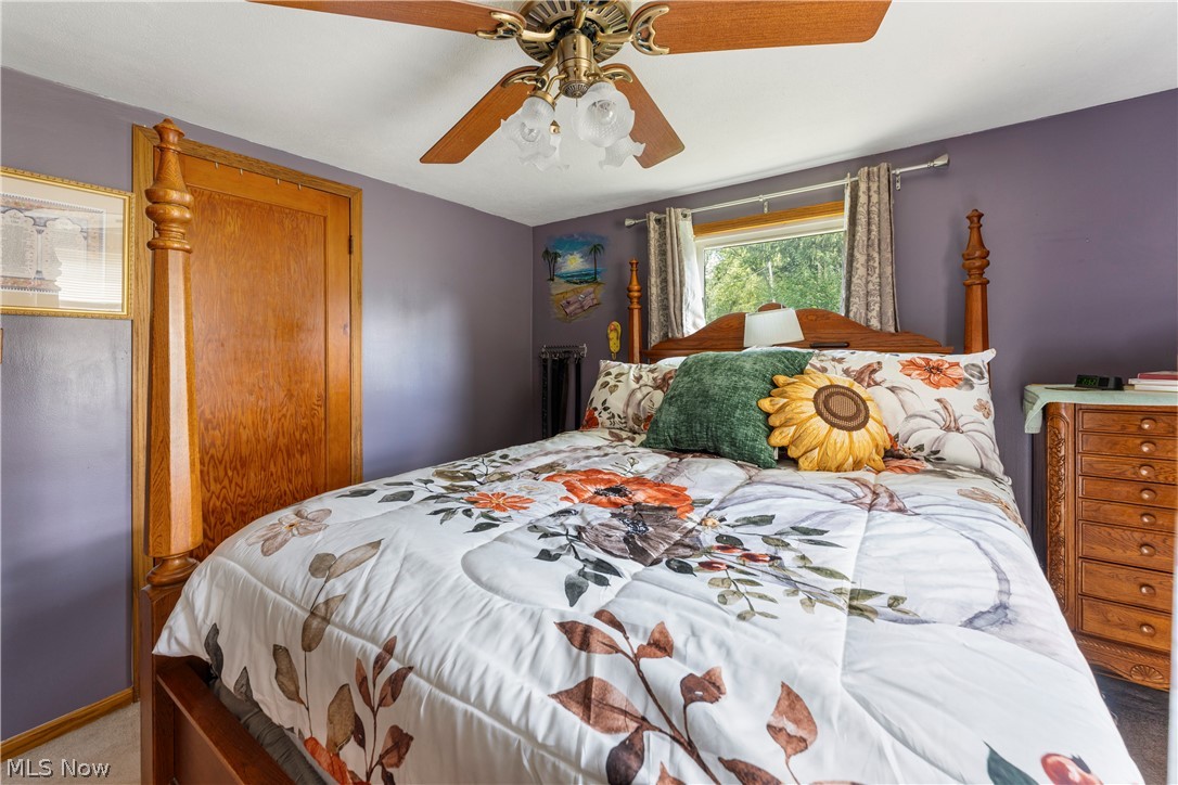 7000 Navarre Road Southwest Massillon, OH 44646 - Photo 17 of 22 This bedroom features a ceiling fan, a window providing natural light, and a wooden door
