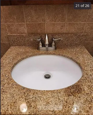 a bathroom with a granite countertop sink and mirror