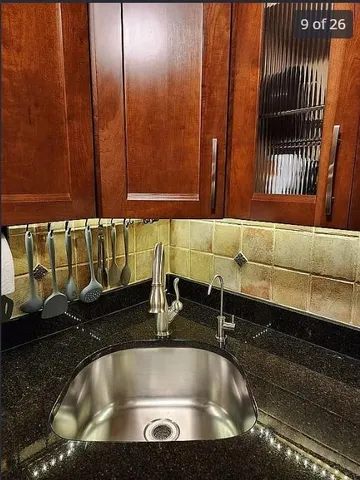 a kitchen with granite countertop a stove a sink a microwave and refrigerator