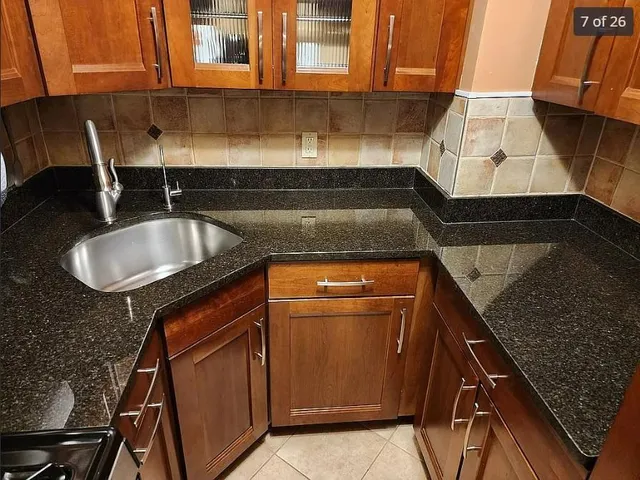 a kitchen with granite countertop a sink and a stove