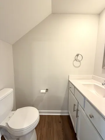 a bathroom with a granite countertop toilet and a sink