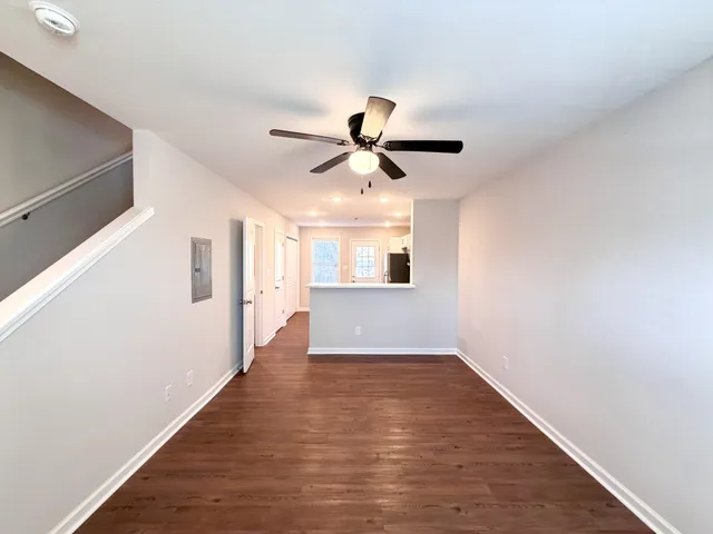 a view of an empty room with window and wooden floor