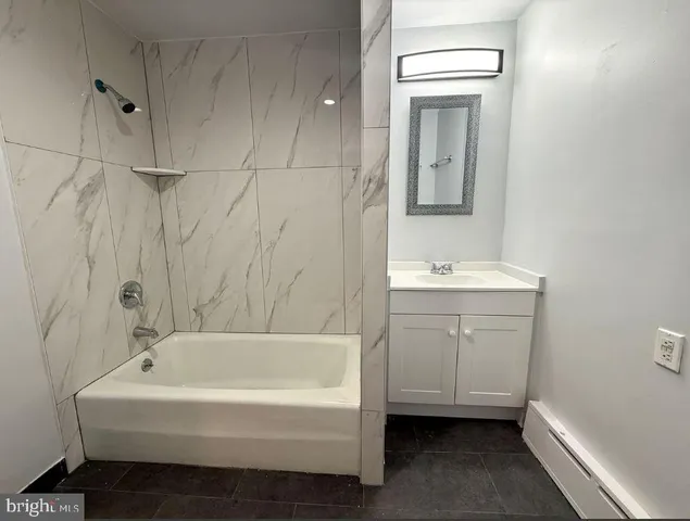 a white bath tub sitting next to a white sink