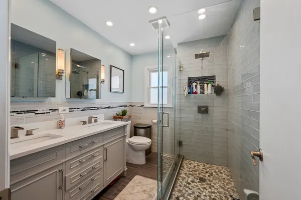a bathroom with a double vanity sink toilet and shower
