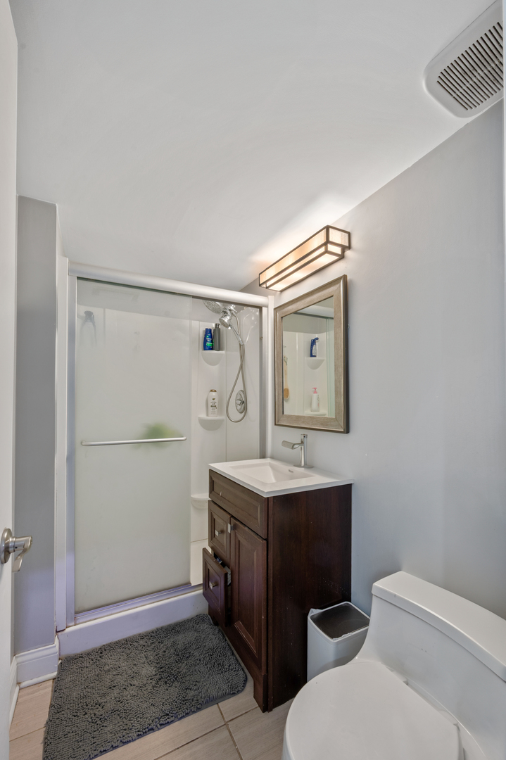 8426 West Betty Terrace Niles, IL 60714 - Photo 25 of 40 a bathroom with a toilet a sink and mirror