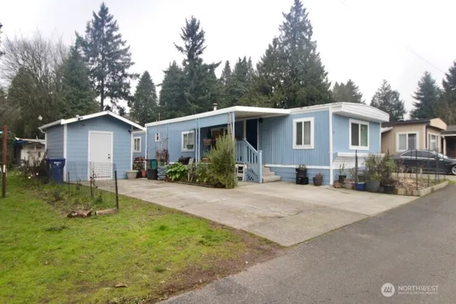 a view of a yard in front of a house with plants and trees