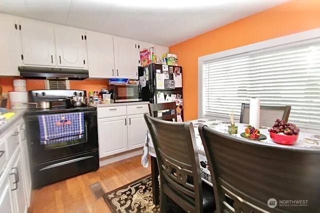 a kitchen with stainless steel appliances kitchen island granite countertop a table and chairs in it