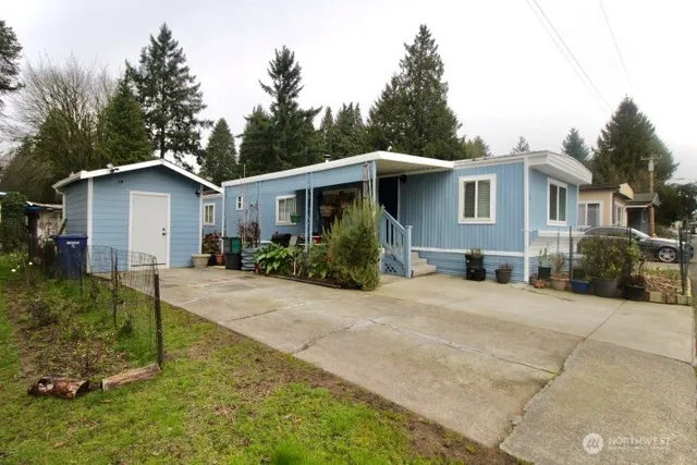 a front view of a house with a yard and trees