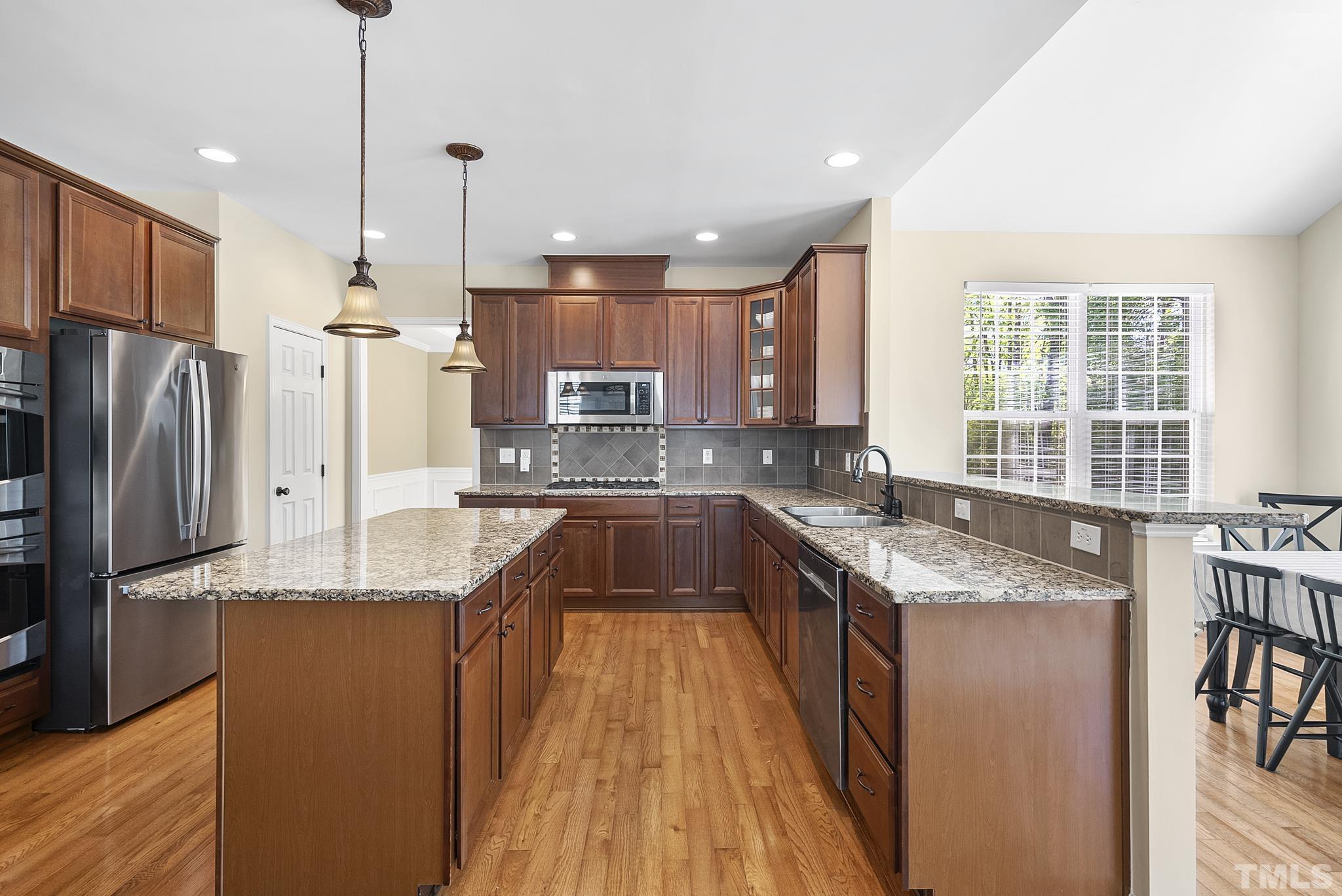 213 Forbes Road Wake Forest, NC 27587 - Photo 11 of 41 a large kitchen with granite countertop a sink a counter space appliances and cabinets