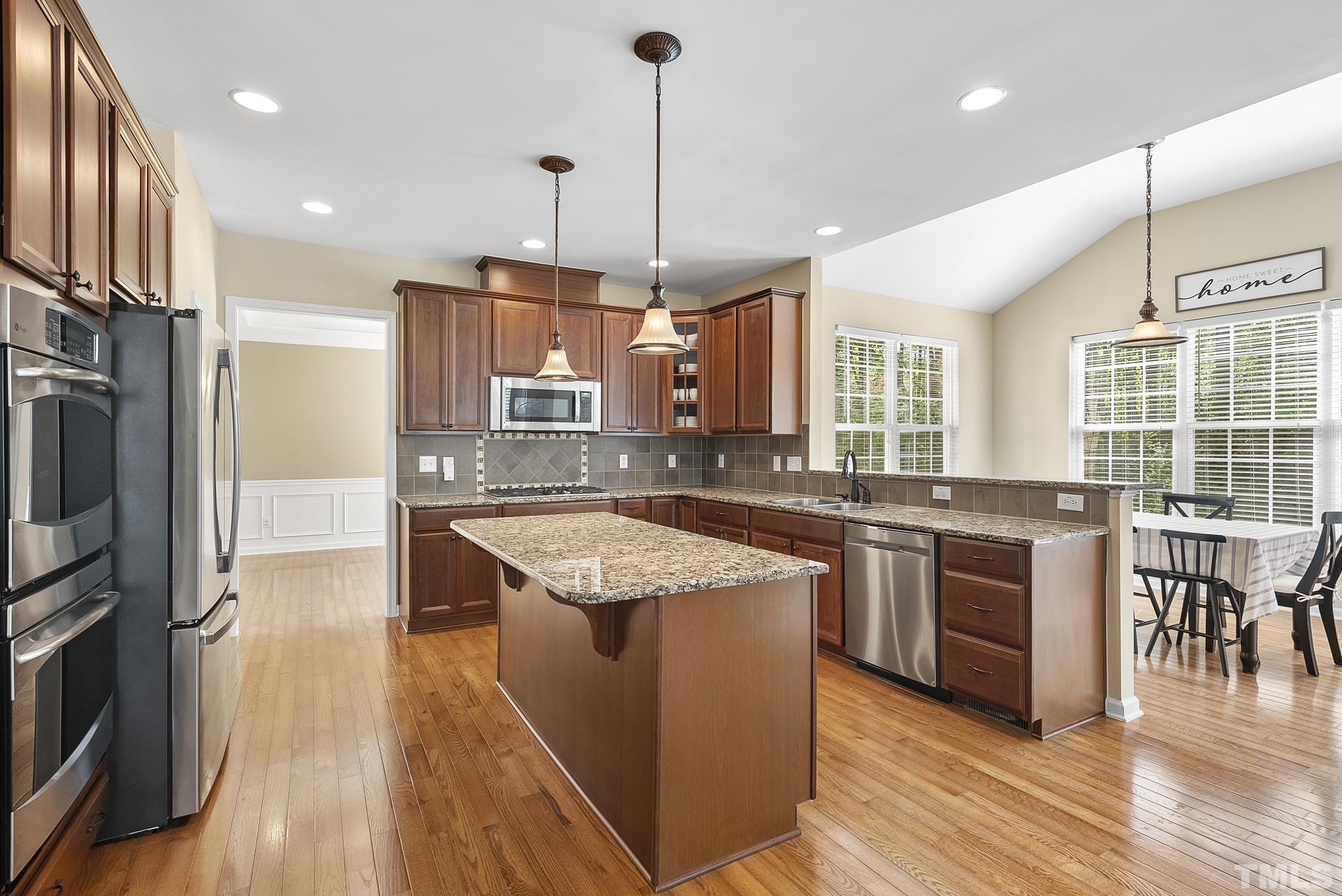 213 Forbes Road Wake Forest, NC 27587 - Photo 12 of 41 a large kitchen with stainless steel appliances granite countertop a stove and wooden floor