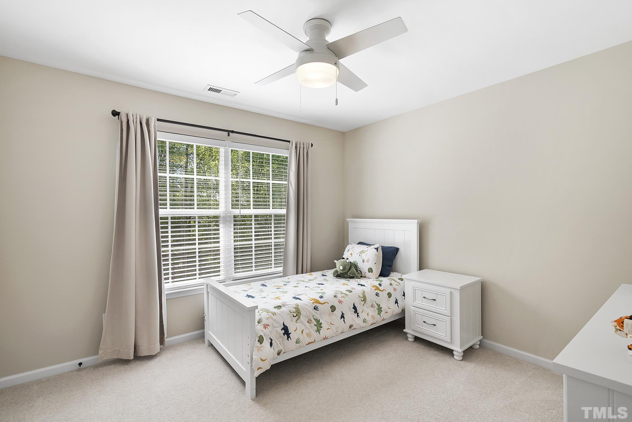 213 Forbes Road Wake Forest, NC 27587 - Photo 31 of 41 a bedroom with a bed and a chandelier fan