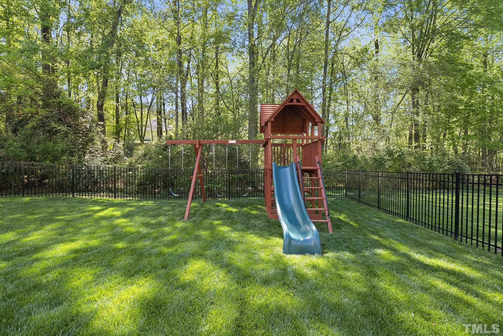 213 Forbes Road Wake Forest, NC 27587 - Photo 41 of 41 a view of a backyard with a slide trees and wooden fence
