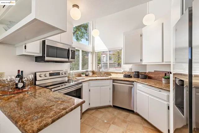 a kitchen with kitchen island granite countertop a sink appliances and cabinets