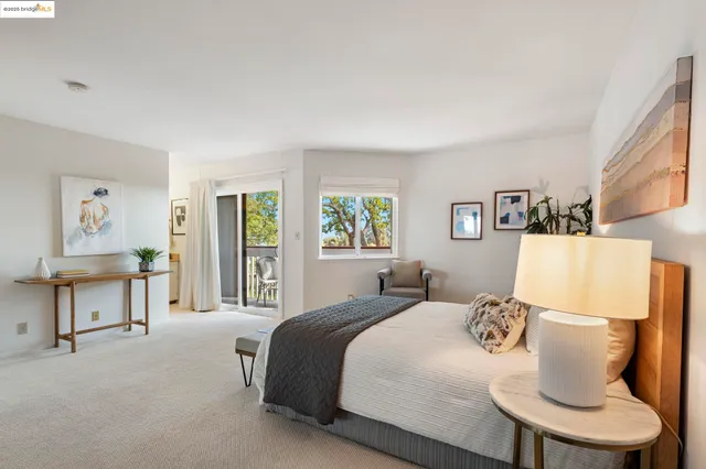 a bed sitting in a bedroom next to a window with lamp
