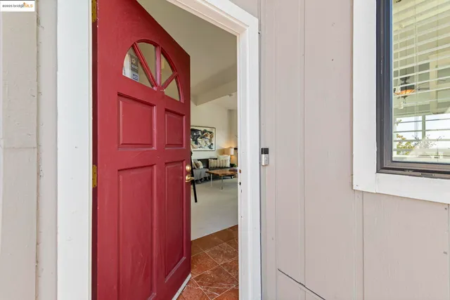 a hallway with a red door and a white door