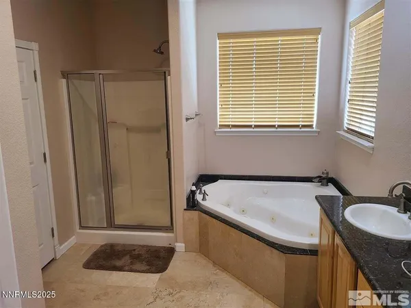 a bathroom with a granite countertop sink and a window